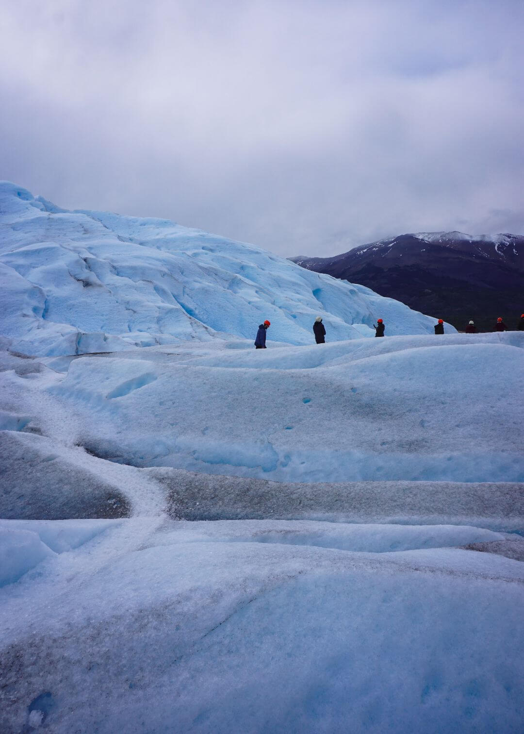 Personas caminando sobre el campo de hielo del glaciar